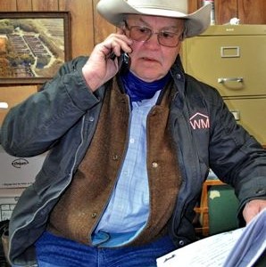 Man wearing cowboy hat, talking on phone.
