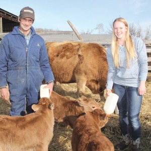 Corney (l) and Janelle help the mother cow out with some supplemental bottle feeding.