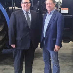two men standing by a tractor