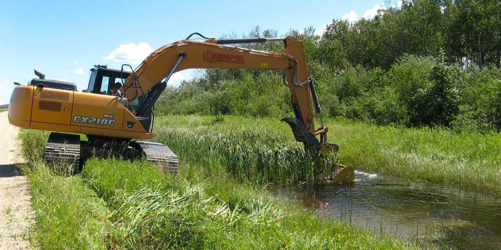 Ditch harvester with water in drain.