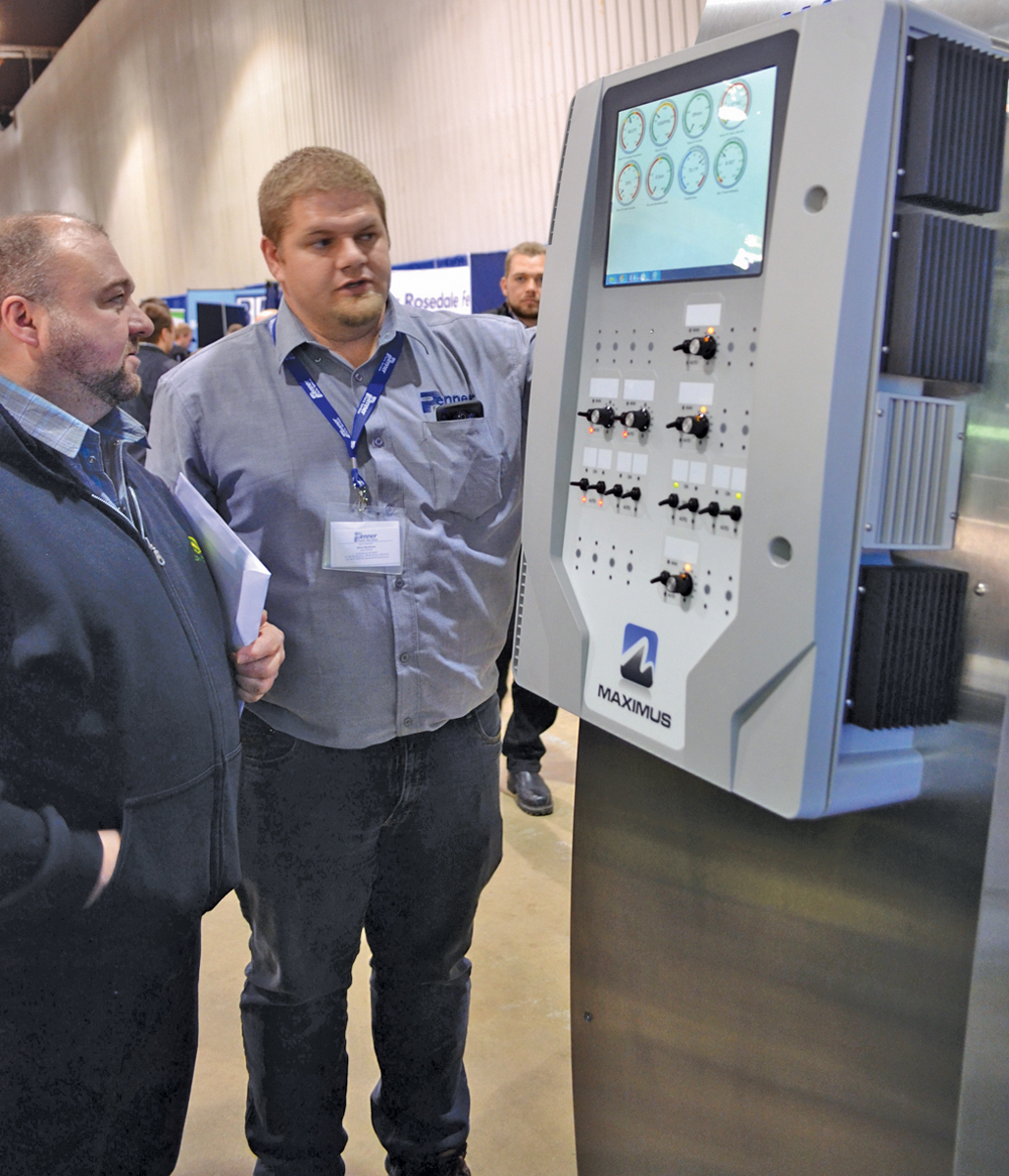 Steve Doerksen, service technician with Penner Farm Services, discussed the Maximus central control system for facility management with an interested producer at the Hog Days event.