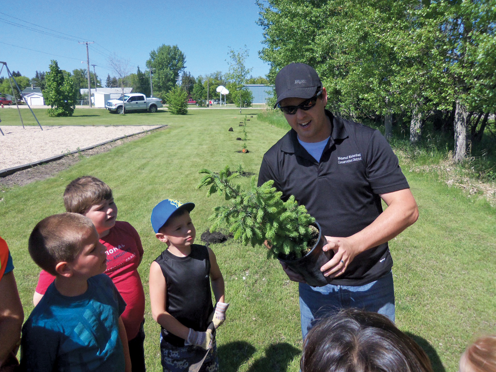Chris Reynolds, manager of the Whitemud Watershed Conservation District provides some students with instructions on tree planting.