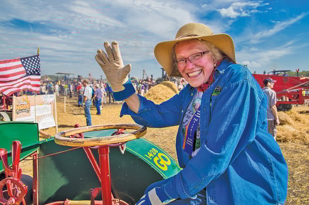 Eileen Ruble of Hanlontown, Iowa, was one of the participants who journeyed from the U.S. to attend the Harvesting Hope event. Here she’s enjoying the moment at the controls of her team’s 1919 General Ordnance tractor.