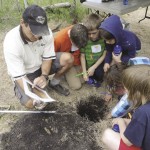 Rejean Picard (MAFRI) leads students in the “dig it” station where students examine soil components and soil water-holding capacity.