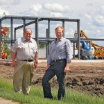 Two men standing on construction site.