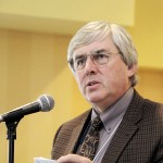 Gordon Harrison speaking into a microphone.