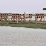 Workers survey the flooding along the Assiniboine Diversion in May 2011. The Manitoba government is investing more in roads, bridges and flood mitigation, but some observers worry not enough in prevention.