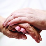 A young hand holding an aged hand.