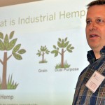 Man speaking in front of viewscreen.