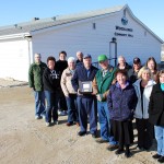 Bob Brad, (centre, holding Volunteer Service Award plaque) is part of the dedicated Woodlands Hall board committee including
Heather Anderson (back row, l-r), Linda Proctor, Barry Proctor, Margaret Anderson, Howard Proctor, Ray Blowers, Tammy Blowers, and Bob Carter, Lisa Lillies (front row, l-r), Bob Brad, Lorelee Proctor, Cindy Procter, and Claudette Carter. Other committee members missing from the photo are Janice Brad and Wendy Proctor.