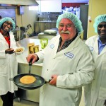 People making millet pancakes in a kitchen.