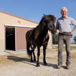 Brett Arnason poses with Ginnar, one of the family’s Icelandic horses kept at their Rosser-area farm.