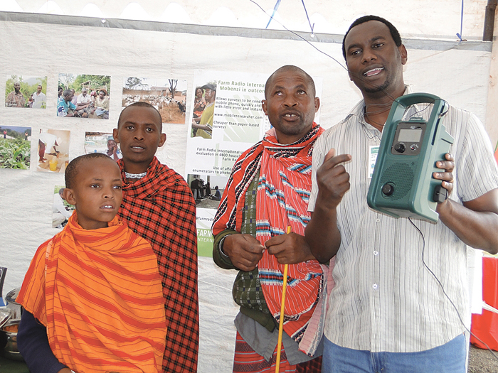 man holding crank-powered radio in Africa