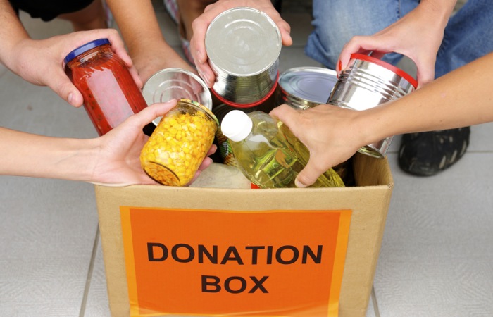 People putting food in a donation box