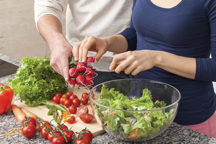 people prepping a vegetable salad