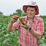 Christian Thierfelder demonstrates how the soil under conventional tillage is rocky and hard. The soil becomes more mellow under conservation agriculture.