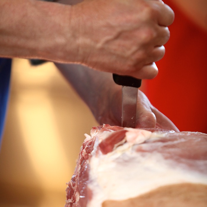 Greg Wood carves into the hog carcass.