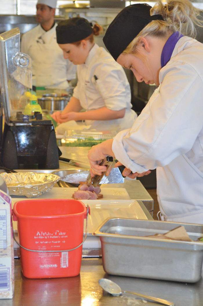 Culinary student, Victoria Clifford slices into her seared duck breast in preparation to plate her appetizer during the Manitoba Canola Growers Association’s Black Box Challenge.