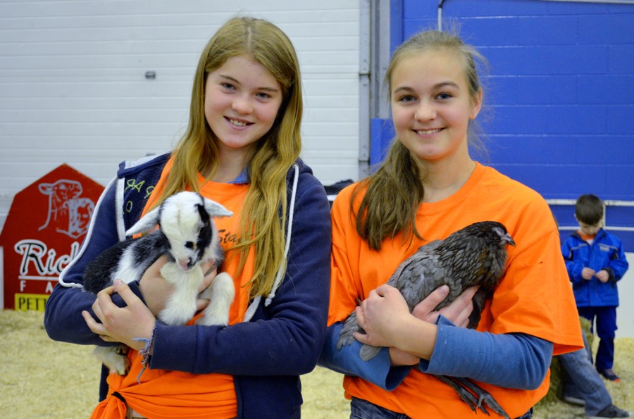 Kieley Mequake and Julia Rosumowitsch hold on to a few of the petting zoo’s creatures as they welcome the public into the hands-on exhibit. 