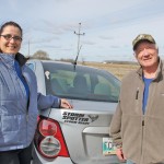man and woman standing beside car