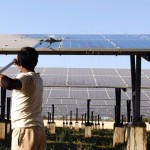 A worker cleans photovoltaic solar panels inside a solar power plant at Raisan village near Gandhinagar, in the western Indian state of Gujarat, February 11, 2014.