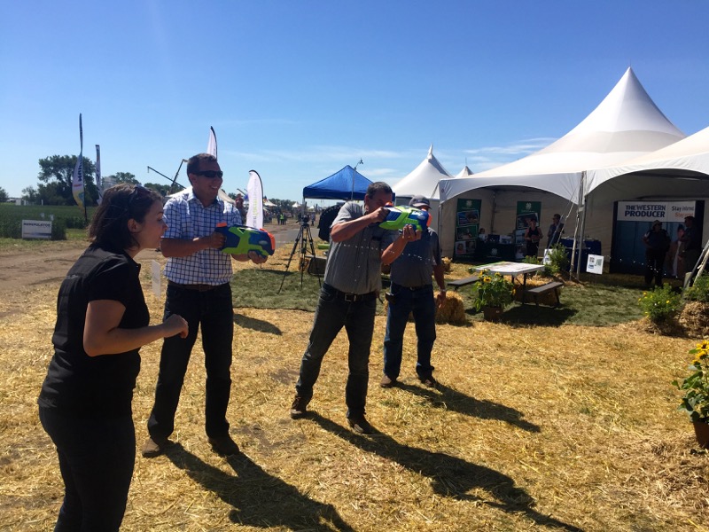 Saskatchewan farmers Henry and Aaron Van Ee take up the rain gauge challenge with water pistols at the CocoRaHs water gun booth.