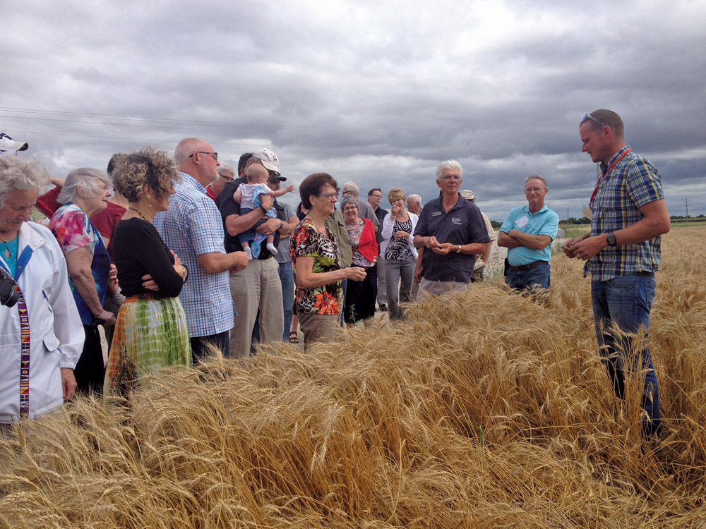 Grow Hope farmer Grant Dyck and some of the people who sponsored an acre this past growing season, at the Grow Hope field, as Grant talks to them about their crop.
