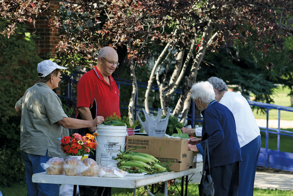 Customers look over the produce marketed by Teenie Yanick and Ernie Peleshok.
