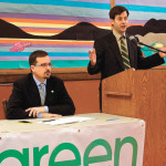 Green Party leader, James Beddome, speaks during a press conference, while David Nickarzn looks on.
