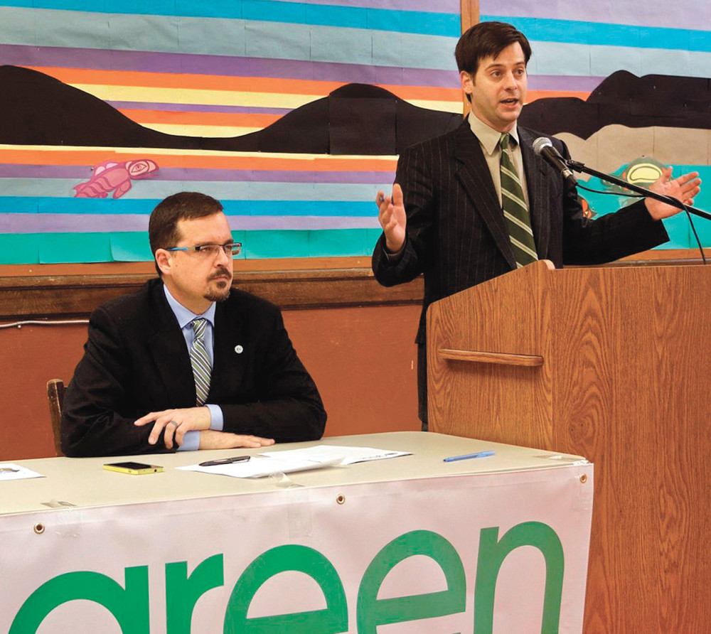 Green Party leader, James Beddome, speaks during a press conference, while David Nickarzn looks on.