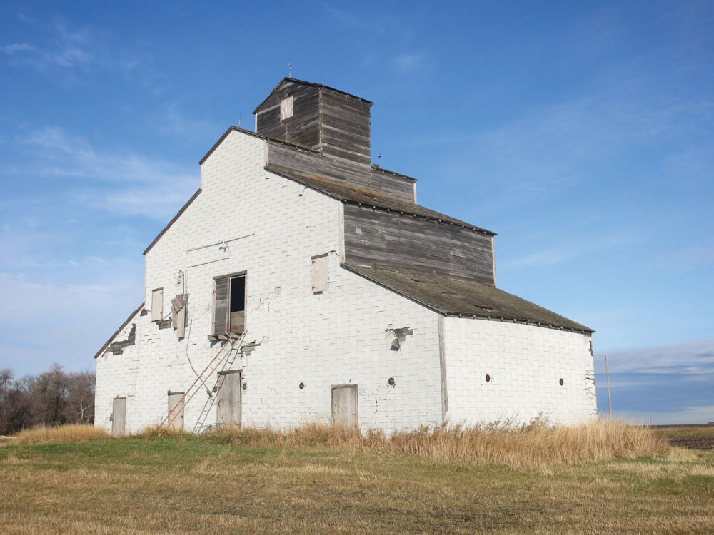 Built in 1945 for landowner Ernest Hoffman as a make-work project for Japanese detainees sent inland from British Columbia during the Second World War, this privately owned grain elevator near Brunkild in the Rural Municipality of Macdonald featured a plaque written in Japanese that gave Hoffman’s initials and the symbol for “prosperity.” Its machinery was dismantled in the 1960s, after which it was used as a granary.