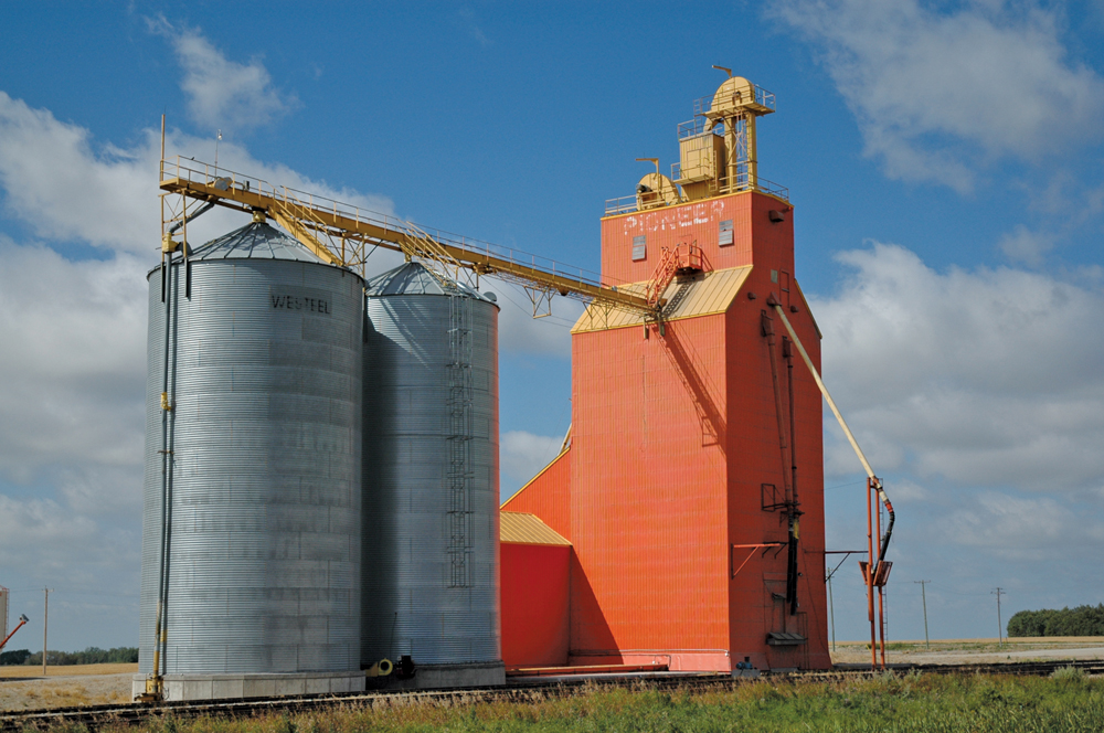 Several companies operated elevators at the railway siding of Glossop,  near Strathclair, in the early days, including A. Forsythe & Company  (1910s), Expert Elevator Company (1910s), Spencer Grain Company (1920s),  and Western Grain Company (1930s-1940s). A wooden grain elevator that  still stands, once owned by Western Grain, was acquired by Pioneer Grain  when it bought the firm in 1952. Renovations included the replacement of  its former red-brown colour with bright-orange paint. Around 2007, the  elevator was sold to Parrish & Heimbecker who gave it the present white  and black colour scheme. A wooden annex built by Pioneer on its west  side, and two steel bins built for a neighbouring Manitoba Pool elevator  on its east side, are now gone.