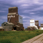 In 1966, when this photo was taken, Angusville had no fewer than four grain elevators operated by three companies: Searle, United Grain Growers, and National. The UGG elevator, second from left, was built in 1934, replacing an elevator that had burned to the ground earlier that year. It was sold to Federal Grain in October 1968 then resold to Manitoba Pool Elevators in 1972. Today, it is the only one left, used by a private company.