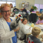 Elaine Owen, Grade 6 teacher at Miami School, holds the classroom’s pet angora rabbit that spends his
days being patted and adored by students when they’re not knitting and spinning.