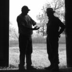 two men in doorway of barn