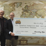 The record-setting Harvesting Hope event at Austin July 31, 2016 raised $134,000, which is being split between the Canadian Foodgrains Bank and the Manitoba Agricultural Museum. Barbara MacDonald director of international programs for the Canadian Foodgrains Bank, (right) accepts a $67,000 contribution from Elliot Sims, one of the organizers of the July 31 event, Harvesting Hope: A World Record to Help the Hungry. Also pictured (at left) is Harold Penner, Canadian Foodgrains Bank regional representative.