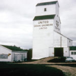 A wooden grain elevator at Gunton, south of Teulon in the Rural Municipality of Rockwood, was built in September 1951, replacing one destroyed by fire on July 24, 1951. This photo from 1964 shows it with the white colour scheme adopted by the company a few years earlier. Norman “Pinky” Herd was the agent from 1952 to retirement in 1980. The elevator closed in July 1984 and was removed.