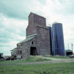 A grain elevator in the RM of Springfield was formerly used by the Scottish Co-operative Wholesale Society to buy Prairie grain for its flour mills in Scotland. Formerly on the CNR line at the siding of Glass, it was moved about two miles northwest of the original site, where it sat at the time of this 1992 photo. The elevator was demolished in 2015.