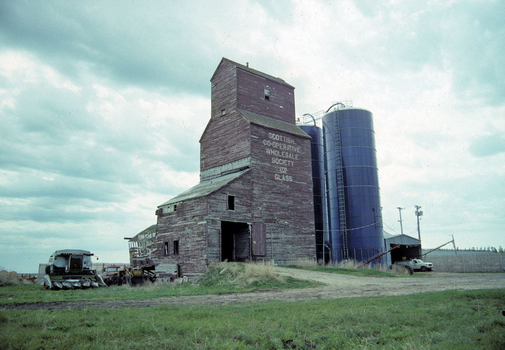 A grain elevator in the RM of Springfield was formerly used by the  Scottish Co-operative Wholesale Society to buy Prairie grain for its  flour mills in Scotland. Formerly on the CNR line at the siding of  Glass, it was moved about two miles northwest of the original site,  where it sat at the time of this 1992 photo. The elevator was demolished  in 2015.