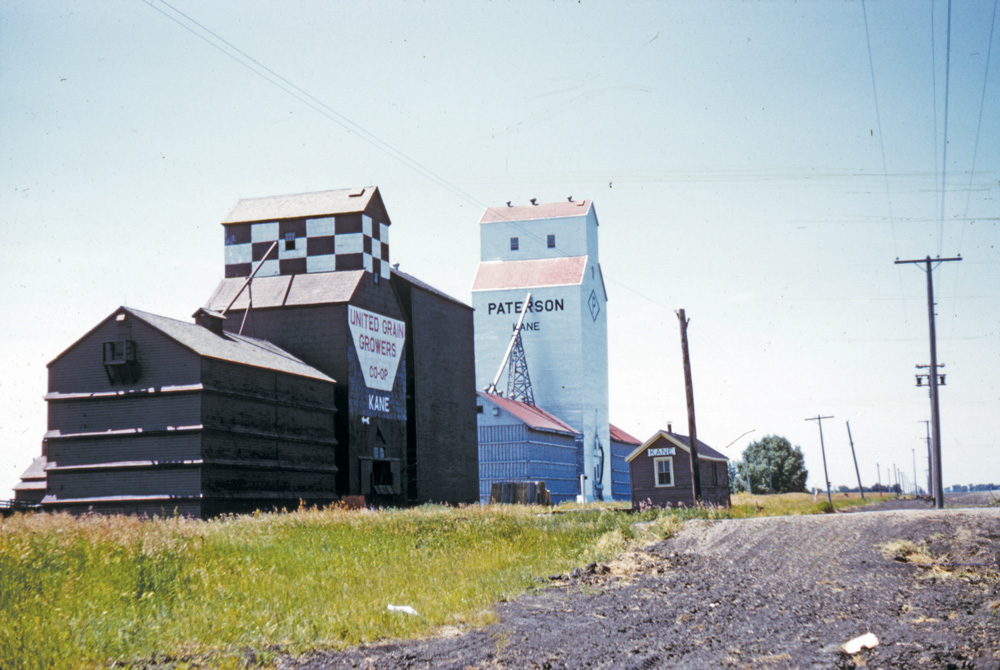 The UGG elevator at Kane, seen in this 1960 photo shortly after its  purchase from the Canadian Consolidated Grain Company, closed in May  1996 and was demolished in August 1996. The Paterson elevator, built in  late 1947 to replace one destroyed by fire earlier that year, still  stands although its two annexes were replaced by a new elevator built in  1982. The railway spur was removed in 2007 but the elevator is used by local farmers for their own grain storage.