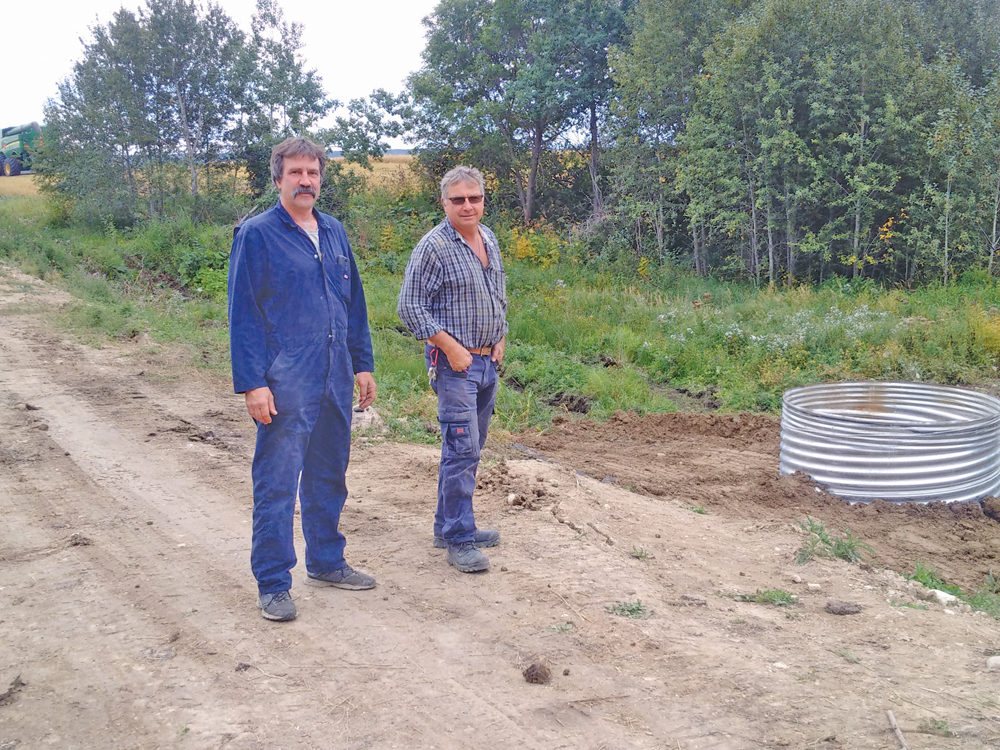 Farm land owner Boris Michaleski (left) and IMCD technician Aaron Kulbacki stand at one of two dry dam sites constructed earlier this year on Michaleski’s farm land to temporarily hold back water during peak flows.