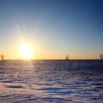 The sun sets over frozen prairie fields near Rosser, Manitoba as temperatures dip below -30 degrees Celsius in mid-December.
