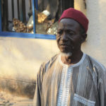 Farmer Ayuba Rasong stands outside of his destroyed home in Kaduna, Nigeria.