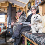 Ron Taylor of Rivers prepares a line as his wife Bonnie works on a crossword puzzle and their dog Delila keeps a watchful eye on the photographer all in the comfort of their ice fishing hut. The Taylors have participated in all 10 of the fish derbies.