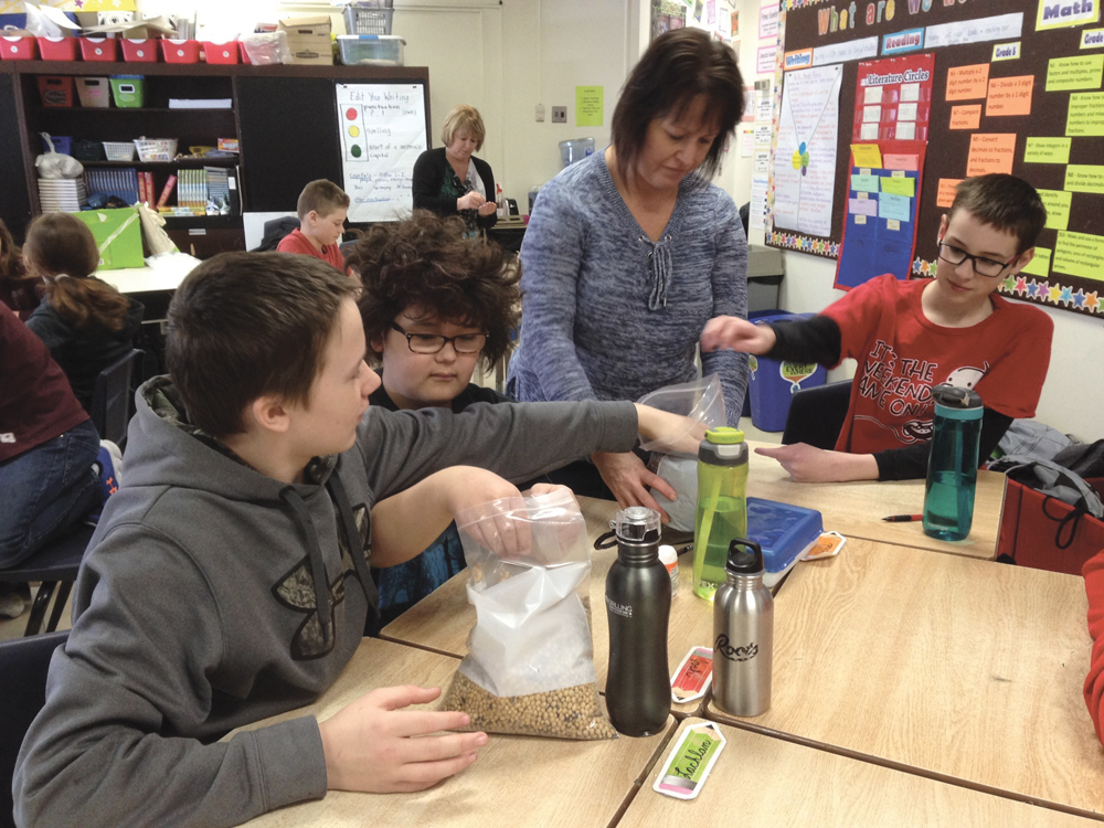 Minnedosa Grade 5/6 teacher Tracy Kingdon passes out different seeds for students to compare.