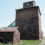 A small wooden elevator at the railway siding of Argue, southeast of Hartney on the long-abandoned CNR Hartney Subdivision, was built around 1918 by the Ogilvie Flour Mills Company. Closed in 1946, the elevator was sold and used for private grain storage by Somerville Brothers Farms from 1951 to 1965. It was still standing at the site as recently as the mid-1990s.