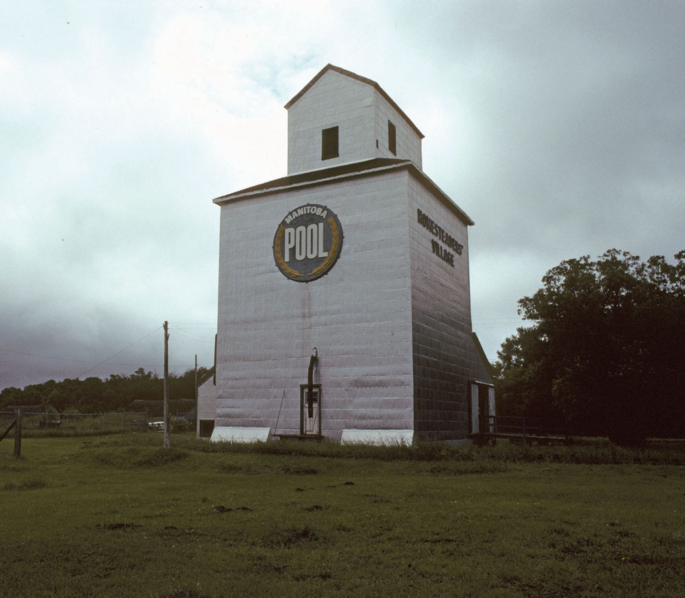 This squat little elevator at the Manitoba Agricultural Museum was  built at Austin in 1901 by the Western Canada Flour Company. With a capacity of just 20,000 bushels, it was sold to Manitoba Pool in 1950 and converted into an annex. In early 1976, in commemoration of the company’s 50th anniversary, the elevator — one of the oldest survivors in Canada — was moved to the museum and restored as part of the Homesteaders’ Village.