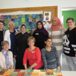 The group (nine of the ten women) was drawn together to make the quilts.