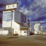 The last remaining wooden grain elevator in Killarney was built in 1953 by United Grain Growers. Seven years later, its initial 100,000-bushel capacity was expanded to 192,000 bushels with the construction of a crib annex on its east side. In late 1999, with newly opened inland terminals nearby that were several times its size, the elevator was sold to Paterson Grain. The building is slated for demolition later this year.