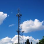 Communications Tower with blue sky and clouds in the background.